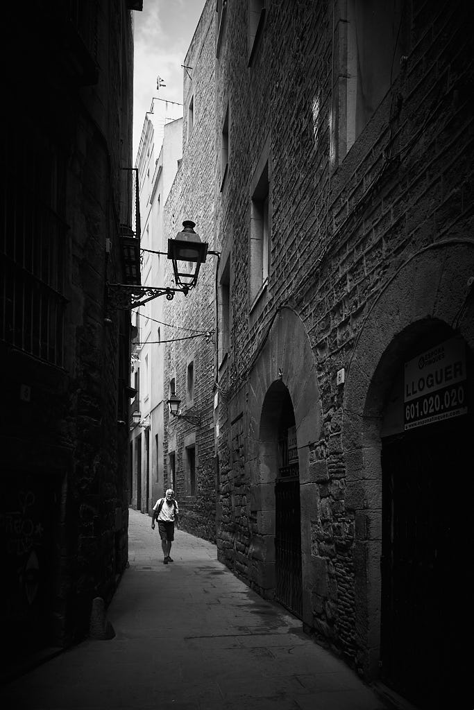 Un senyor es passeja pel carrer de Marlet, en el Call Jueu del Barri Gòtic de Barcelona.