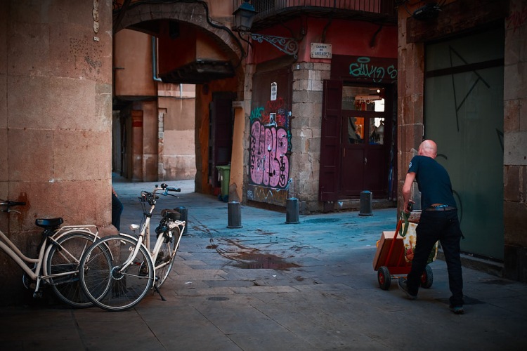 Man delivering with a wheelbarrow in El Born, in Barcelona Old Town.