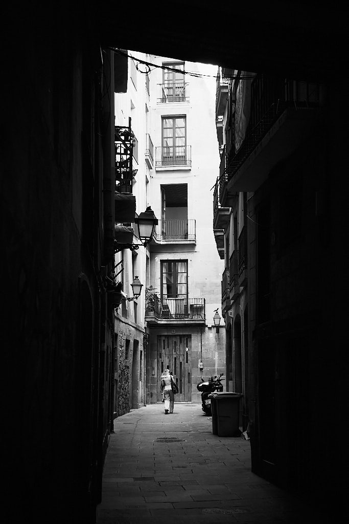 Female figure walking through Giriti Street, an alley of El Born, in the Old Town of Barcelona.